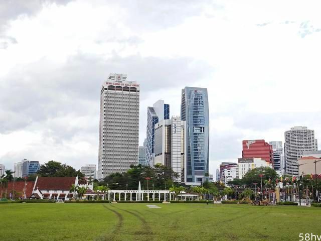 马来西亚独立广场，可以看到最顶端的建筑，行人随便踩草坪